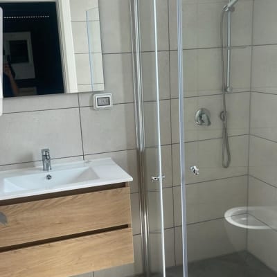 מקלחון זכוכית, כיור עם ארון עץ, ראש מקלחת