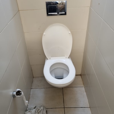 אסלה עם ניאגרה סמויה ומגבת על הרצפה