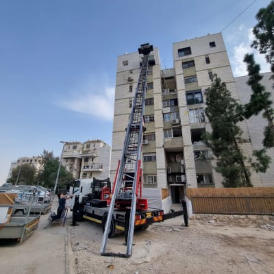 מנוף על משאית ליד בניין מגורים