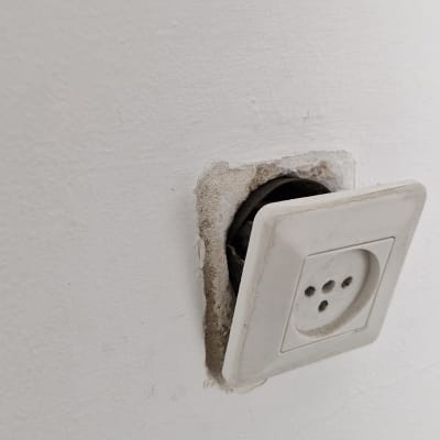 שקע חשמלי בקיר עם חוטים חשופים