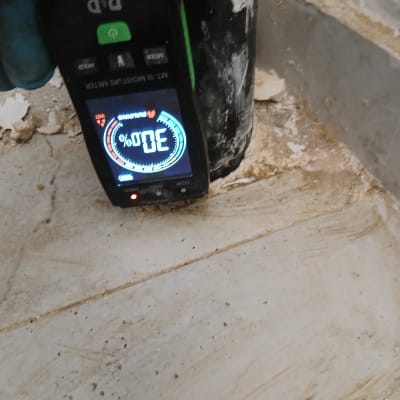 מד לחות דיגיטלי מציג 30% על קיר רטוב