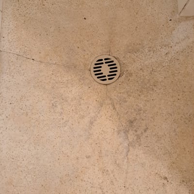 רצפת מקלחת עם ניקוז עגול וסדקים ברצפה