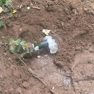 צינור מים דולף מכוסה בניילון באדמה