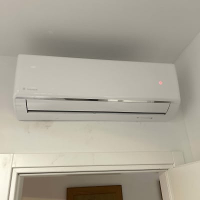 מזגן קיר לבן מותקן מעל דלת