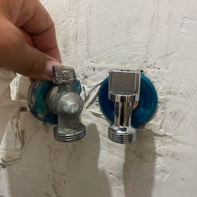 ברזים מותקנים על קיר עם יד מחזיקה אחד מהם