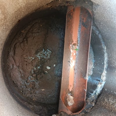 צינור כתום בתוך בור עם בוץ ולכלוך