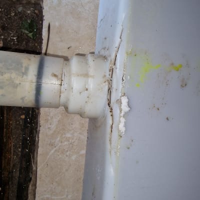 צינור פלסטיק מחובר למיכל עם סדק ודליפה