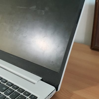 מחשב נייד עם מסך כבוי ומקלדת על שולחן עץ