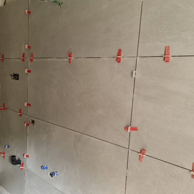 קיר עם אריחים אפורים ומחברים אדומים