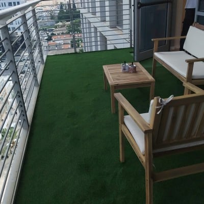 מרפסת עם דשא סינתטי וריהוט גן מעץ
