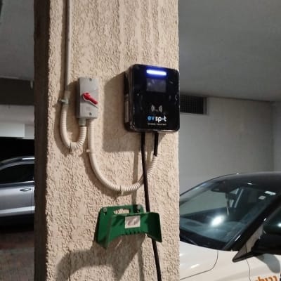 עמדת טעינה לרכב חשמלי עם כבל חשמל על עמוד