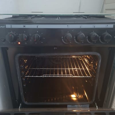 תנור אפייה עם דלת פתוחה ומדפים פנימיים