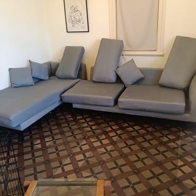 ספות אפורות עם כריות על רצפה מעוצבת