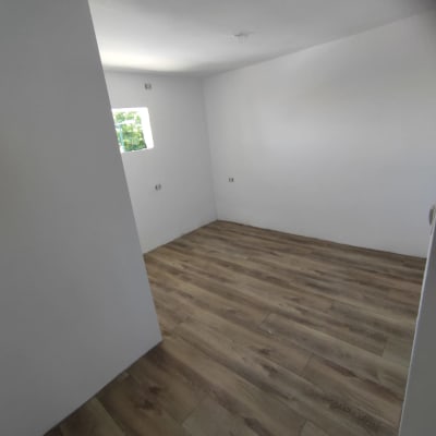 רצפת פרקט עץ בחדר ריק עם קירות לבנים