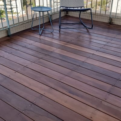 רצפת עץ במרפסת עם כיסא ושולחן קטן