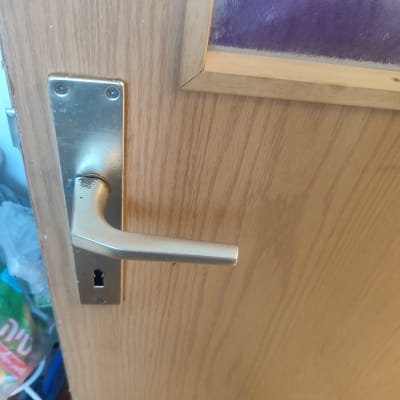 ידית דלת מתכת על דלת עץ