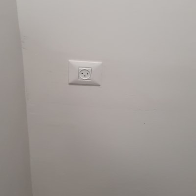 שקע חשמל מותקן על קיר לבן עם כלי עבודה על הרצפה