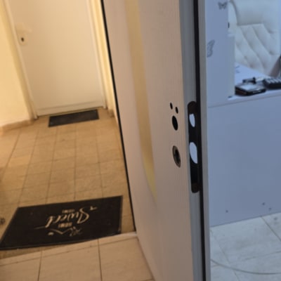 דלת פתוחה עם מנעול חלקי וכלי עבודה על הרצפה