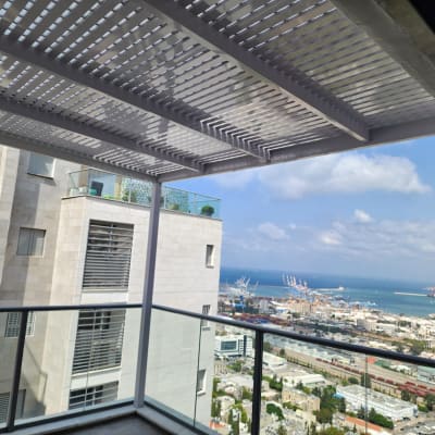 פרגולה מאלומיניום על מרפסת עם נוף לים