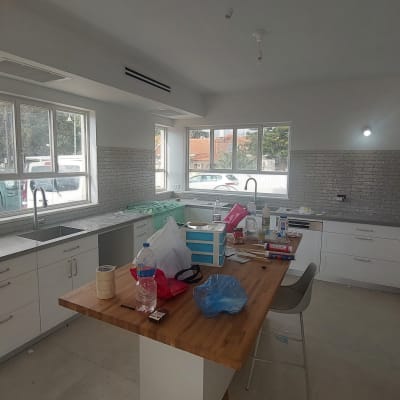 מטבח בשיפוץ עם כלים וחומרים על השיש