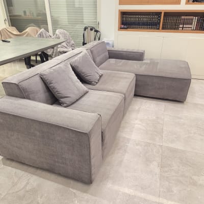 ספה אפורה בחדר מגורים עם שולחן וכיסאות