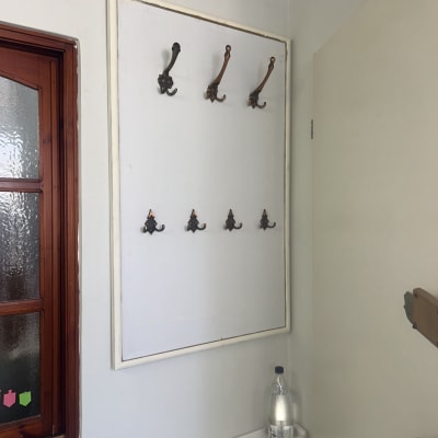 קיר עם מתלים ומדף פלסטיק ליד חלון