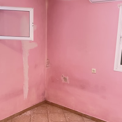 קיר ורוד עם סימני תיקון וכתמים