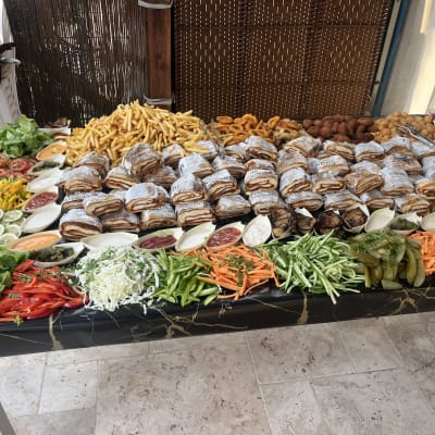 שולחן עם מגוון מאכלים, ירקות, לחמים וצ