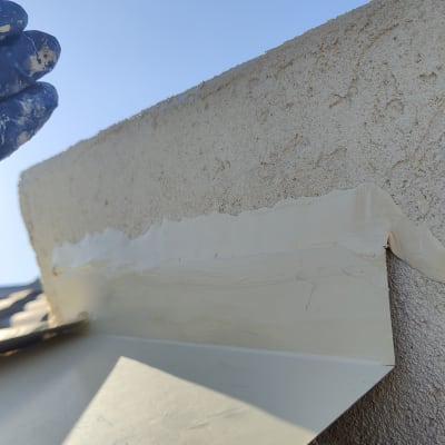 יד עם כפפה מורחת חומר איטום על קיר