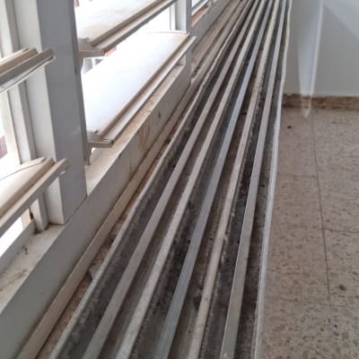 תריסים מלוכלכים עם אבק ולכלוך על אדן החלון