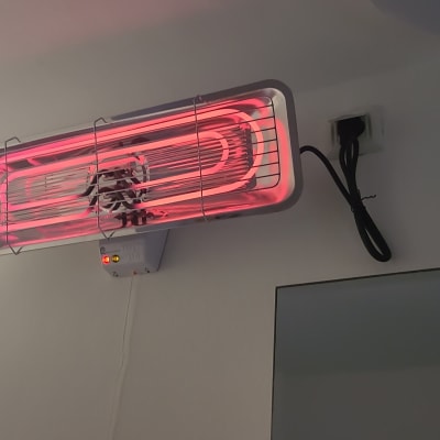 תנור חימום חשמלי מותקן על קיר עם כבל חשמל