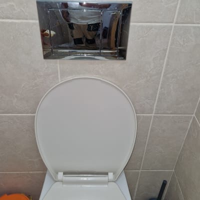 אסלה עם מנגנון הדחה וקיר אריחים