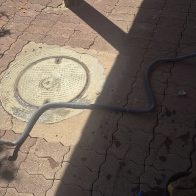 צינור על רצפת אבן ליד מכסה ביוב