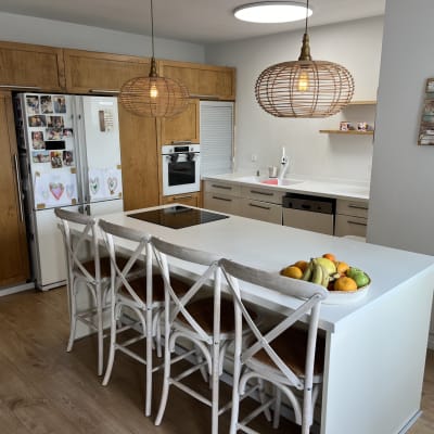 מטבח מודרני עם אי, כיסאות עץ ופירות על השיש