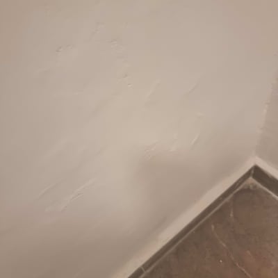 קיר עם טיח לא אחיד ליד רצפה