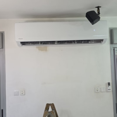 מזגן מותקן על קיר עם סולם מתחתיו