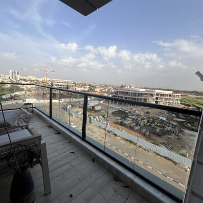 מרפסת עם נוף של אתר בנייה ועגורנים