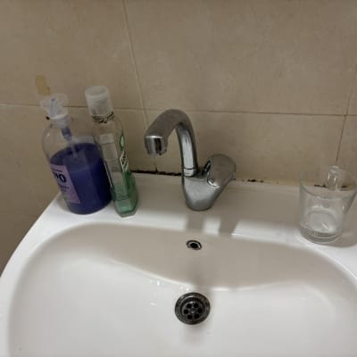 כיור עם ברז, סבון נוזלי וכוס זכוכית