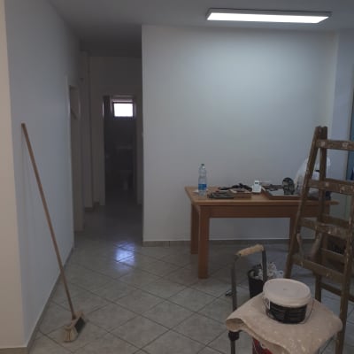 סולם, דלי צבע, מברשת ומטאטא בחדר צבוע