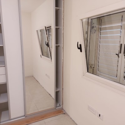 חלון פתוח עם תריסים, ארון עם מראה