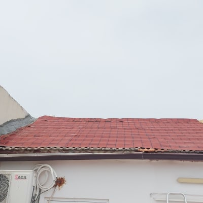 גג רעפים אדומים עם תיקון בטון בפינה