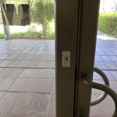 אינטרקום מותקן על דלת זכוכית עם ידית מתכת