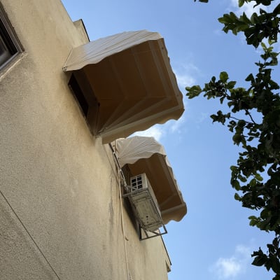 שני סוככים על קיר בניין עם שמיים כחולים