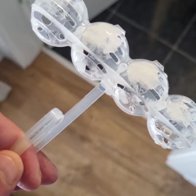 מכשיר פלסטיק שקוף עם כדורים לבנים