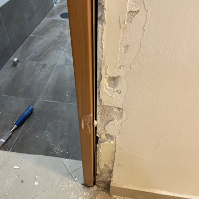 משקוף דלת עץ עם קיר מתקלף ותיקונים