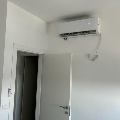 מזגן מותקן על קיר לבן עם שלט רחוק