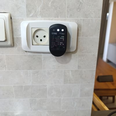 בודק חשמל מחובר לשקע בקיר