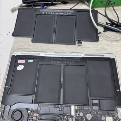 מחשב נייד פתוח עם סוללה ומקלדת ברקע