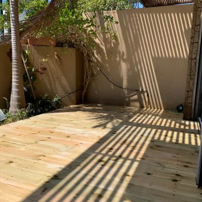 רצפת עץ חדשה בגינה עם צללים על הקיר