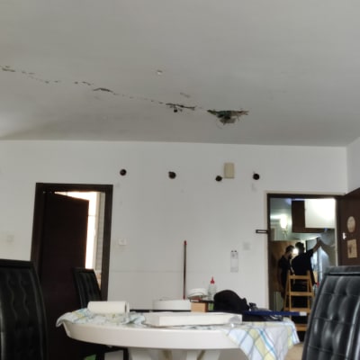 חשמלאי עובד על תקרה עם סולם וכלים